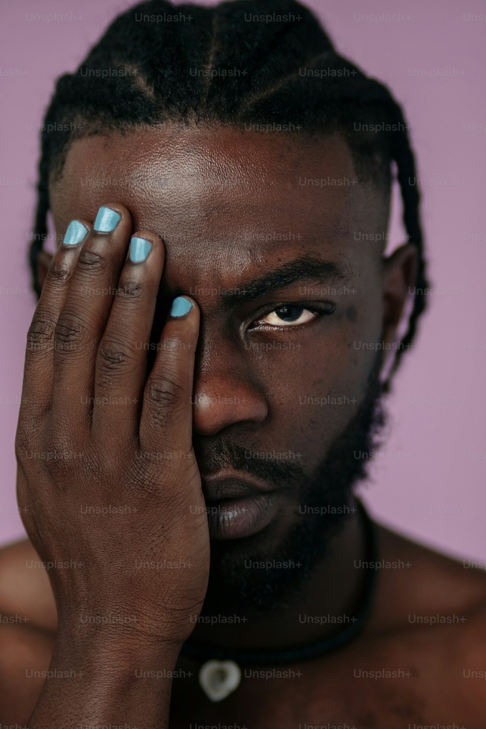 a man with dreadlocks holding his hand to his face