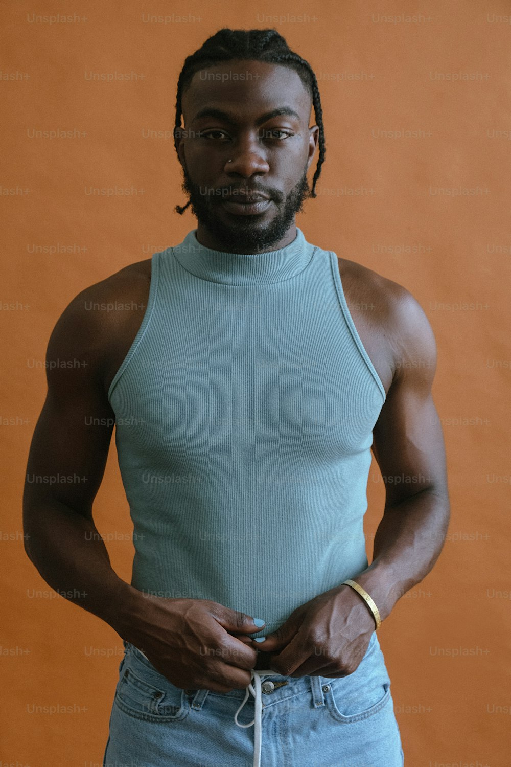 a man with dreadlocks standing with his hands in his pockets
