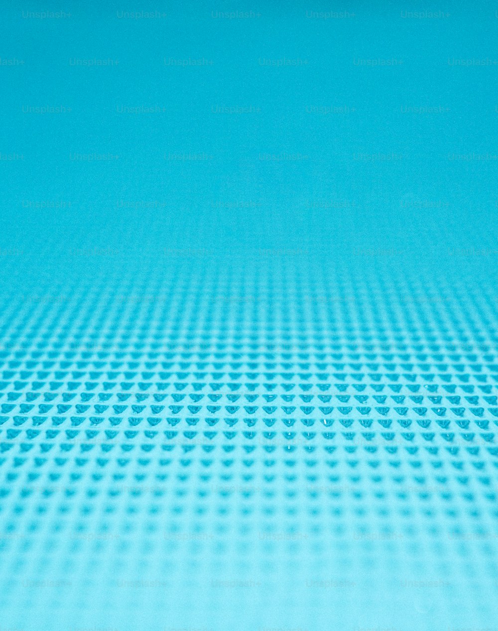 Un primer plano de una superficie azul con pequeños círculos