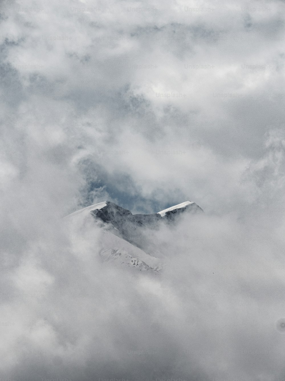 a view of a mountain covered in clouds