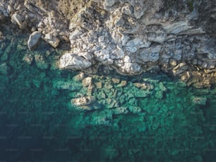 an aerial view of a body of water near a rocky cliff