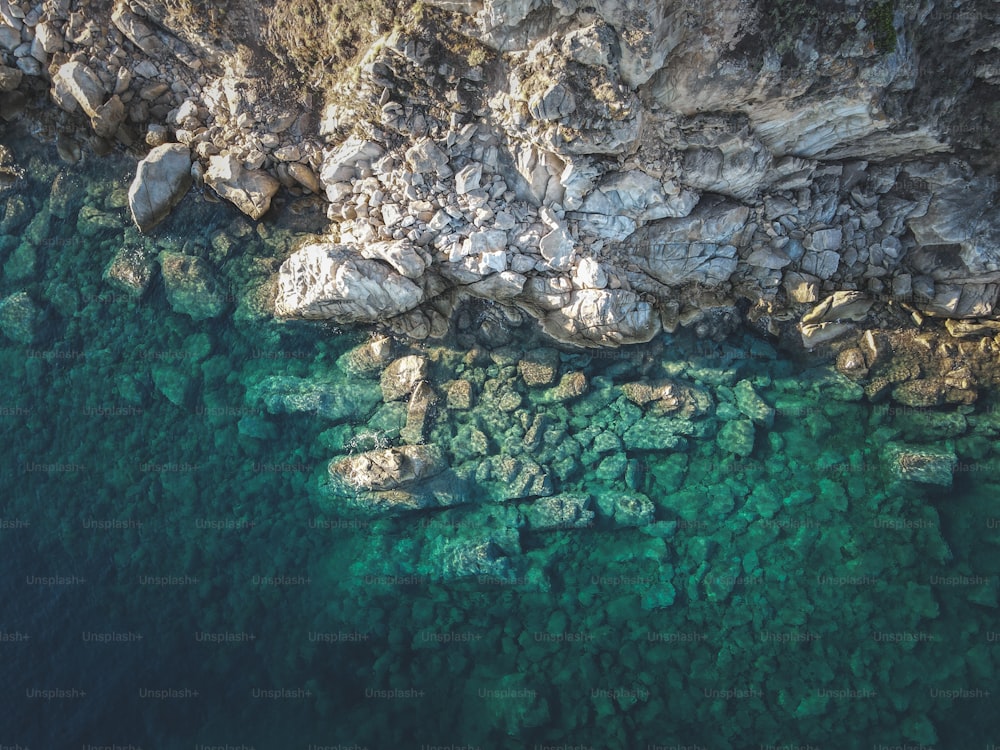 an aerial view of a body of water near a rocky cliff