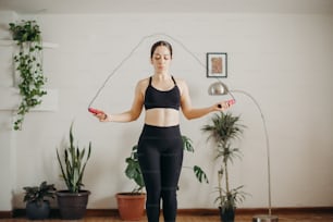 a woman in a black sports bra top holding a bottle and a pair of scissors