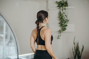 a woman in a sports bra top looking at a mirror