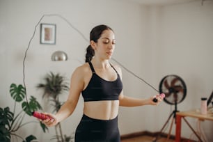 a woman in a sports bra top holding a skipping rope