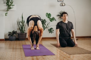 Un hombre y una mujer haciendo yoga en una habitación