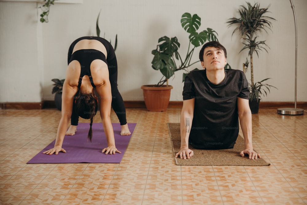 Un hombre y una mujer haciendo yoga en una habitación