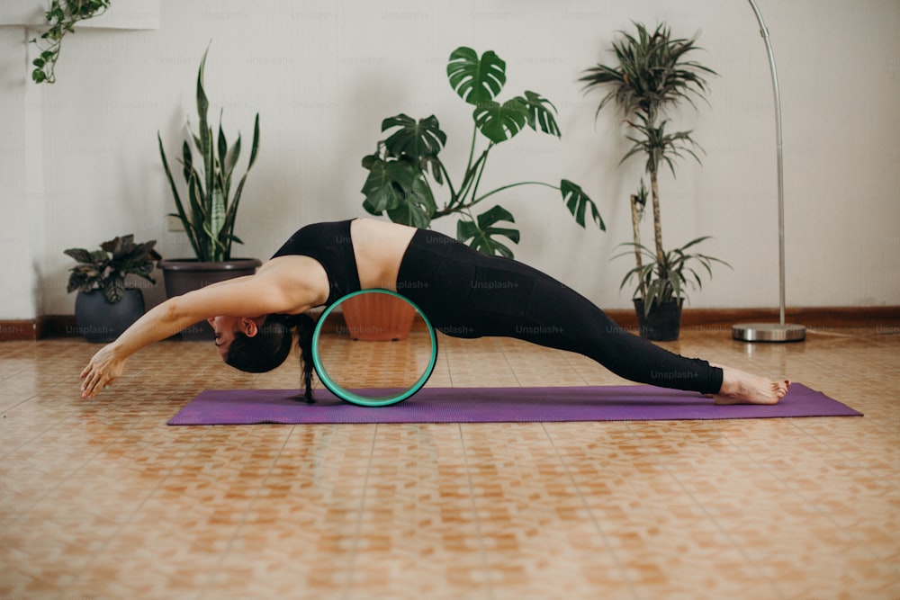 a woman doing a yoga pose on a yoga mat