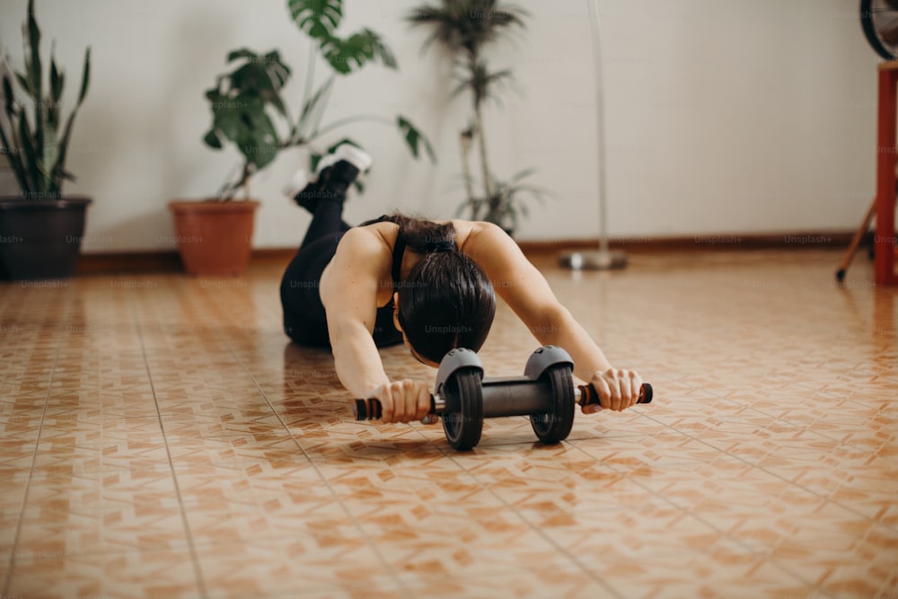 a woman is doing a push up with a dumbbell