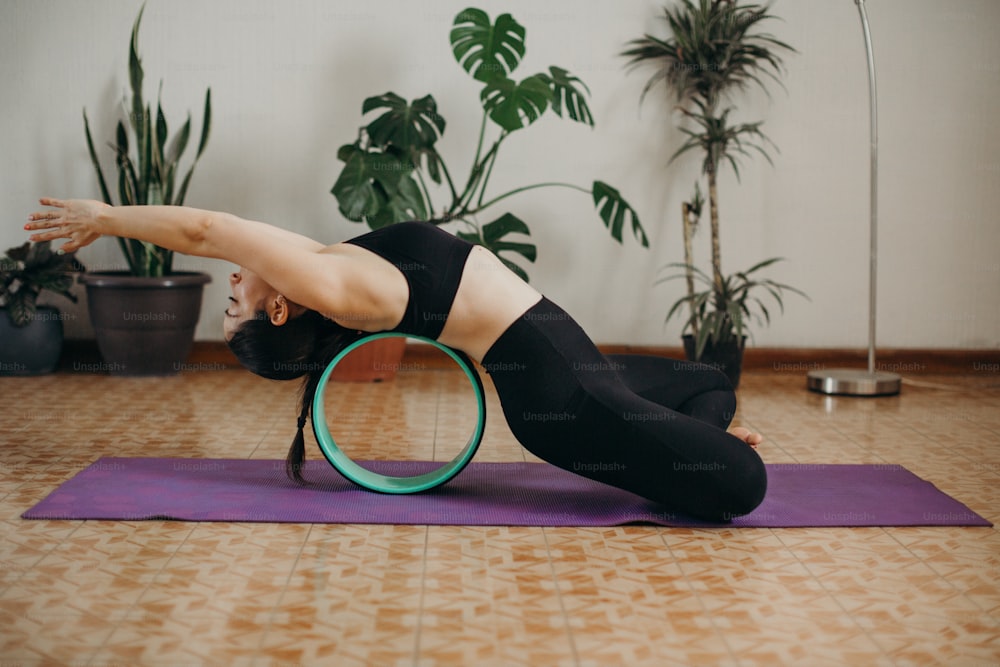 a woman in a black top is doing a yoga pose