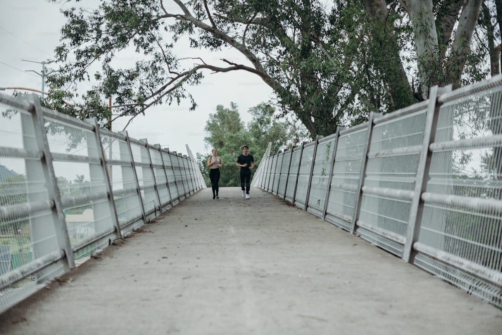 Un par de personas caminando por un puente