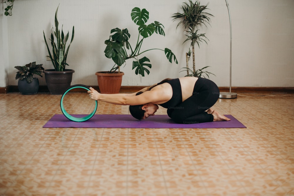 Una mujer está haciendo una postura de yoga en una colchoneta