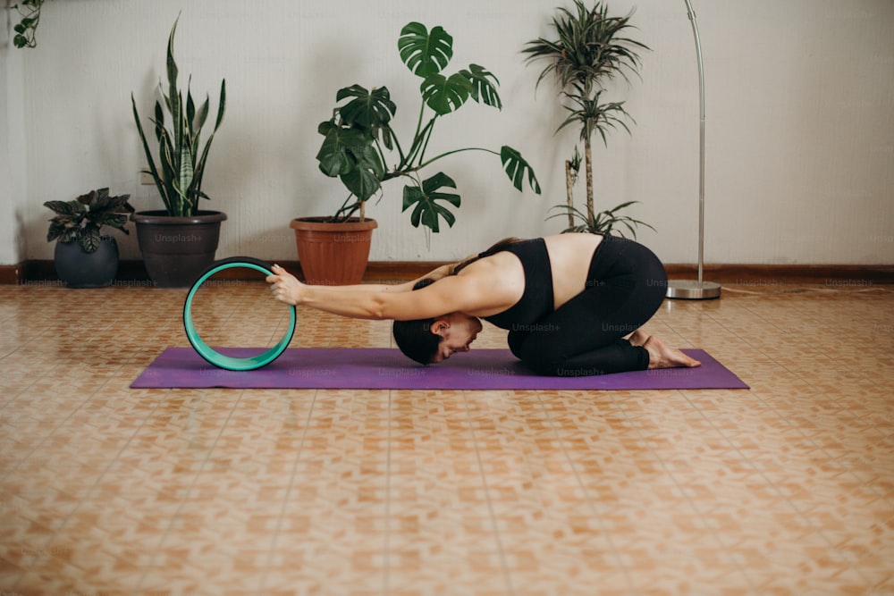 a woman is doing a yoga pose on a mat