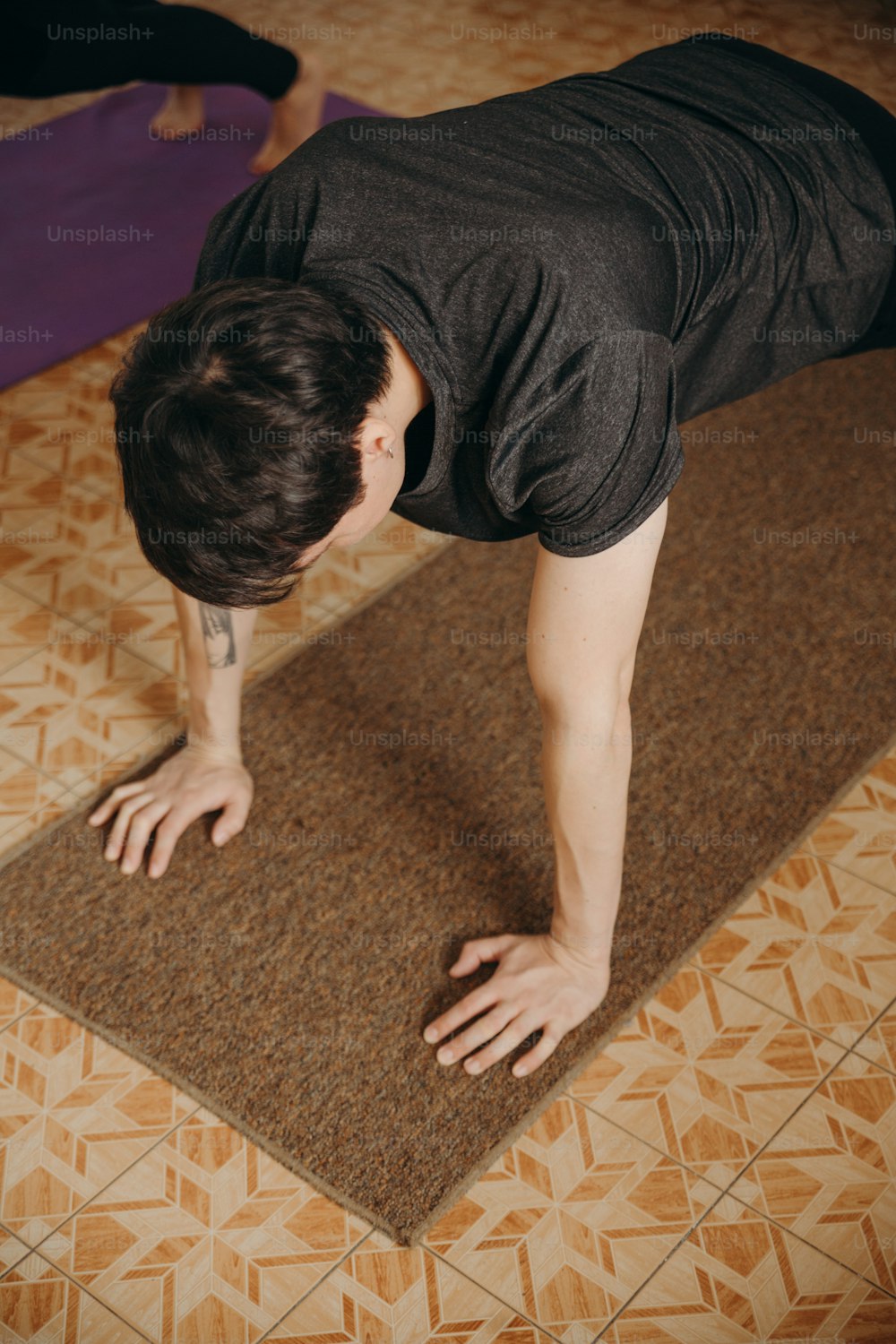 um homem em pé em um tapete de ioga fazendo um suporte de mão