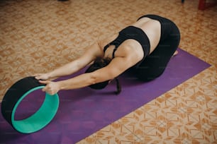 Una mujer está haciendo una postura de yoga en una colchoneta