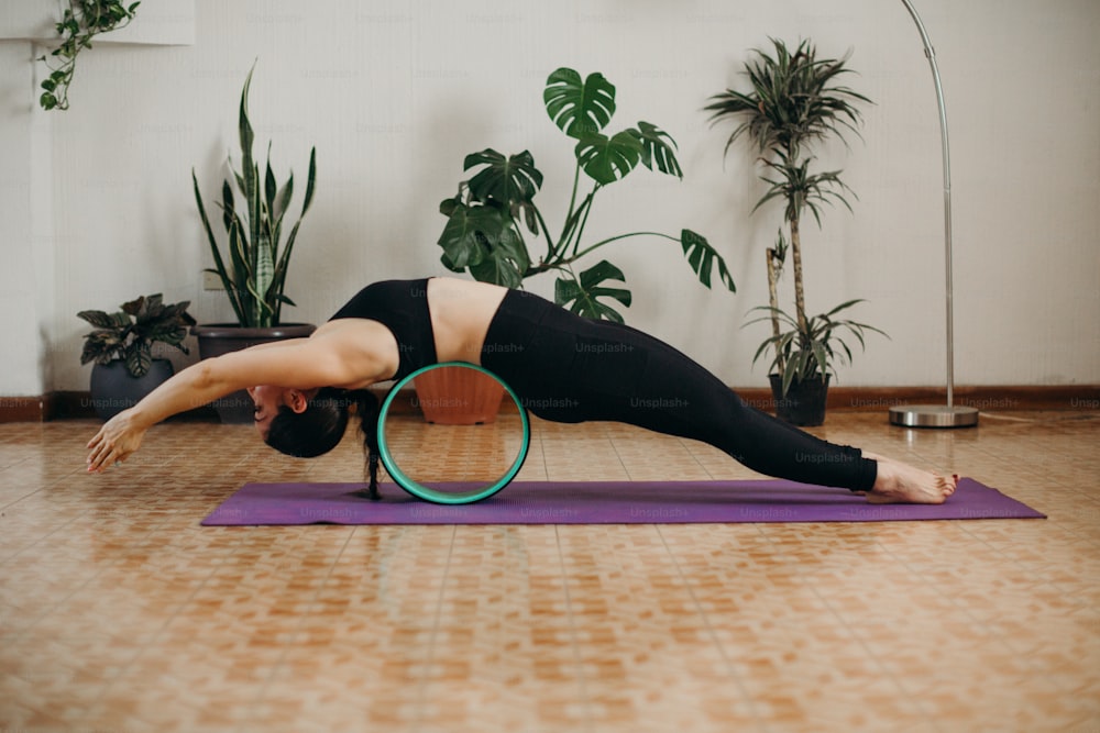 a woman doing a yoga pose on a yoga mat