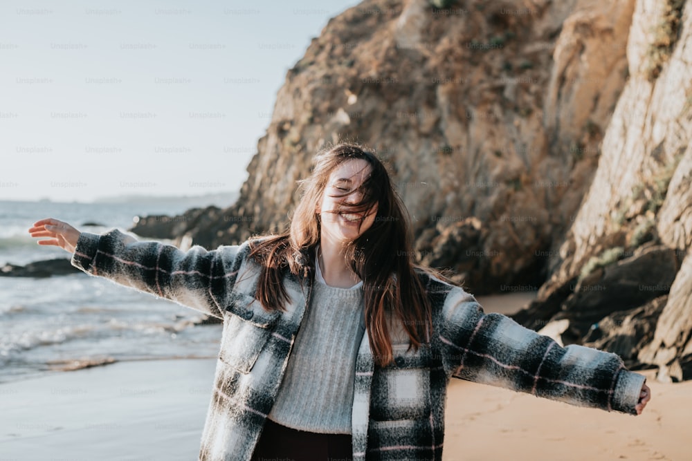 a woman standing on a beach next to the ocean