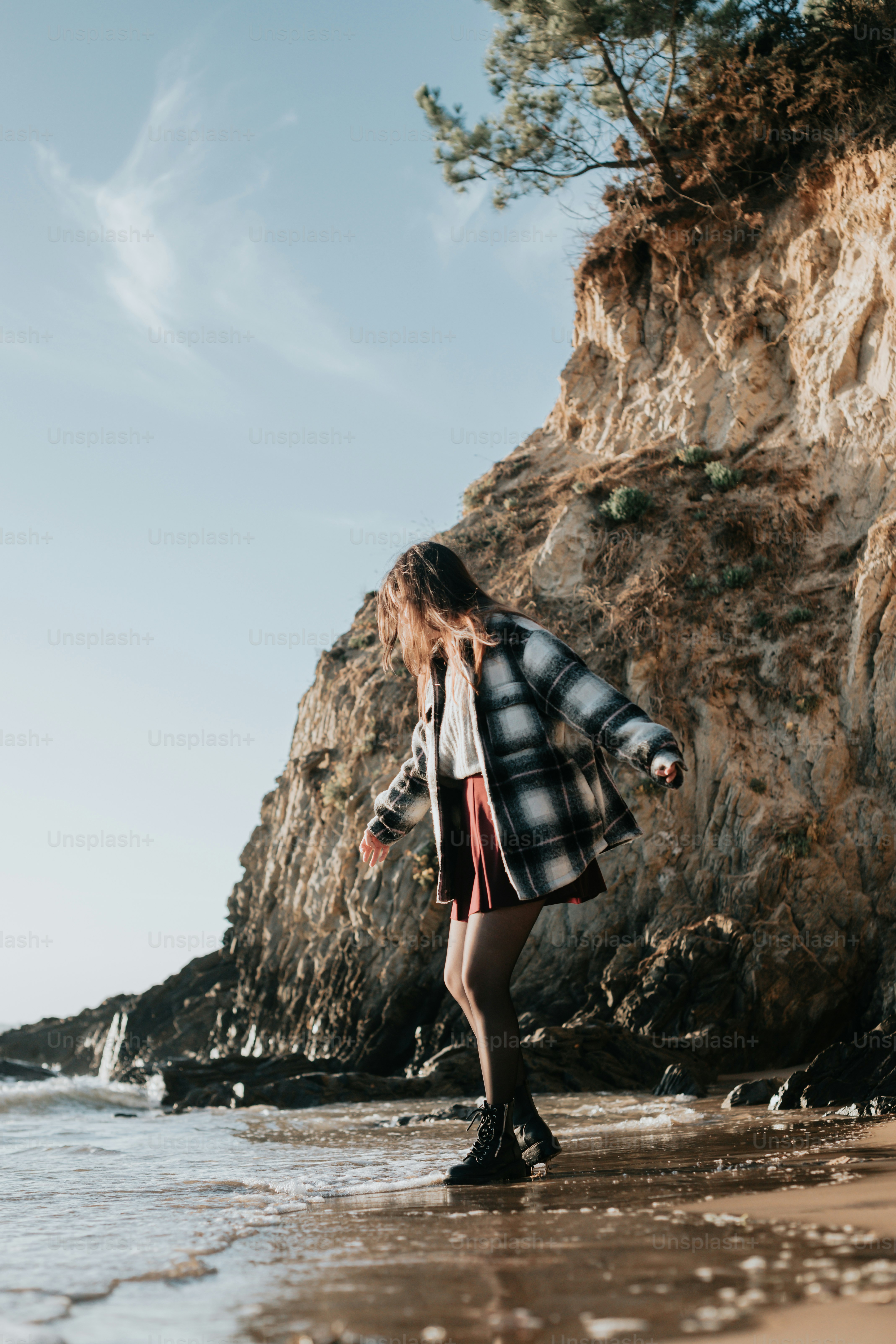 Una donna in piedi sulla cima di una spiaggia sabbiosa