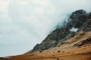 a very tall mountain with some clouds coming out of it