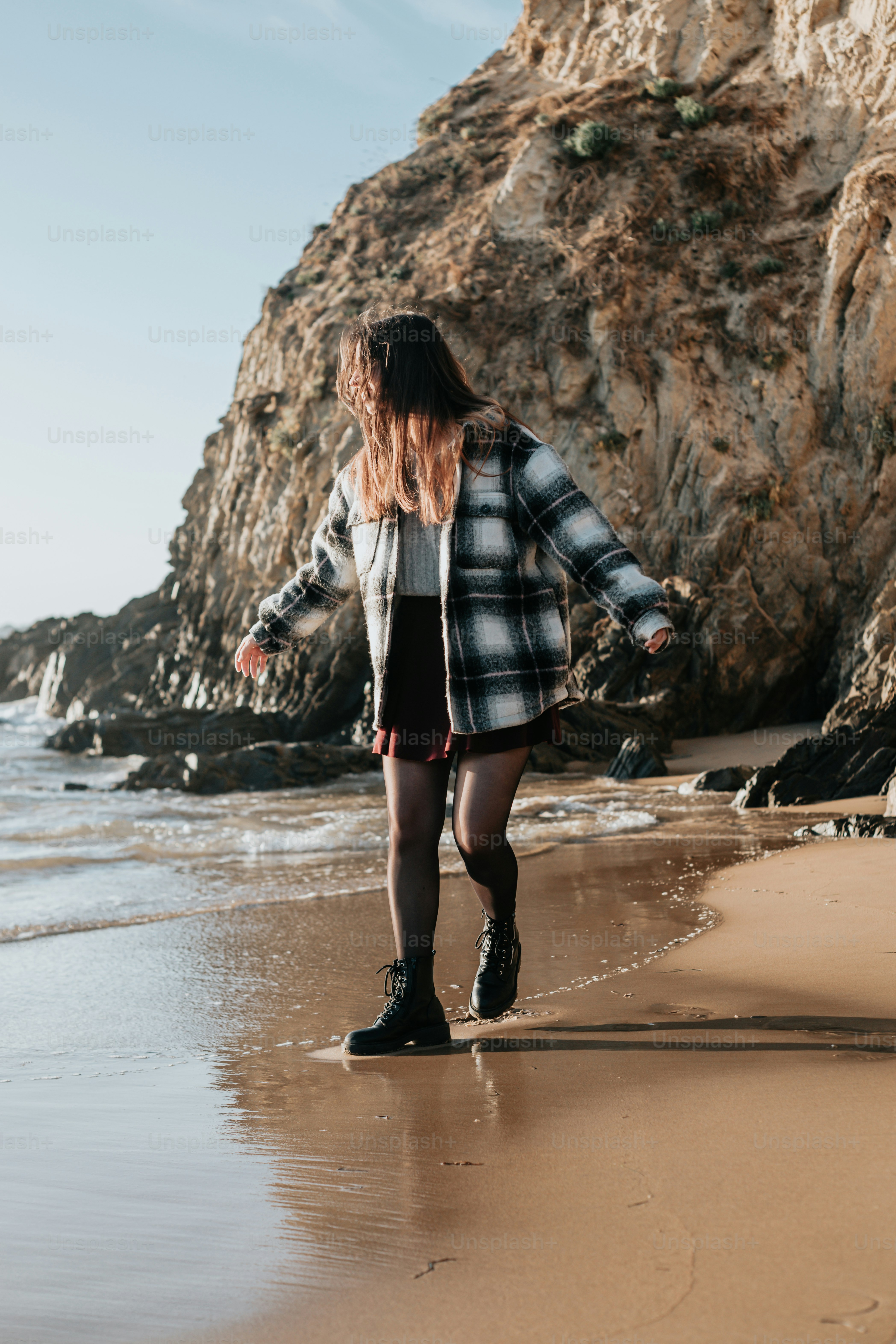 Una donna in piedi sulla cima di una spiaggia sabbiosa