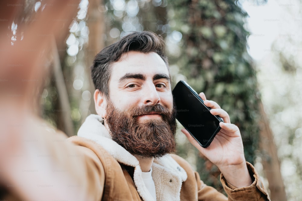 Ein Mann mit Bart, der mit einem Handy spricht