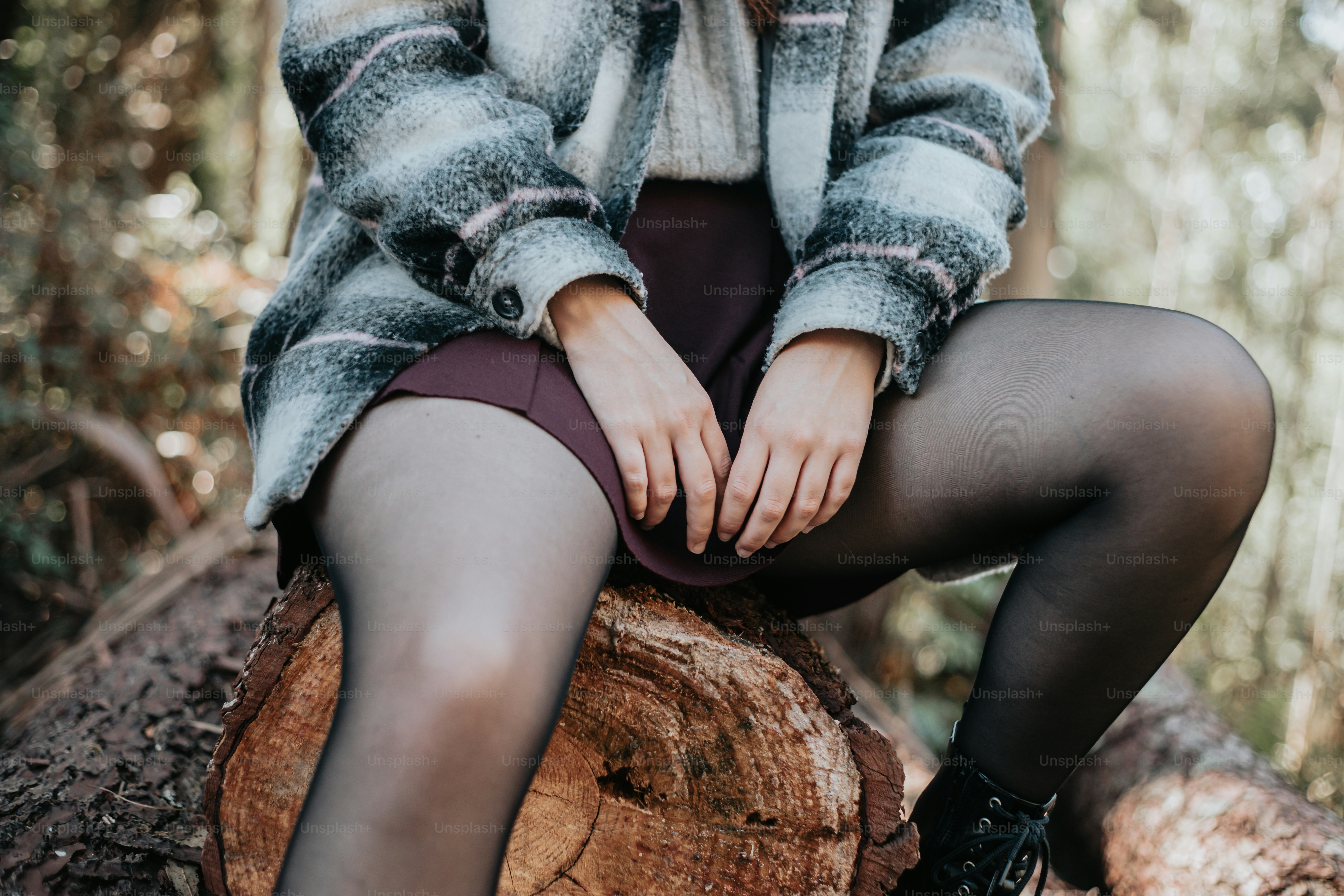 a woman sitting on top of a tree stump