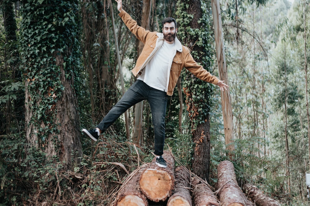 a man standing on a log in the woods