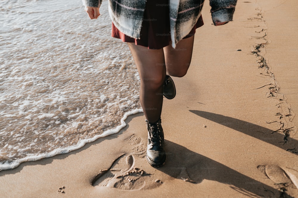 uma mulher caminhando ao longo de uma praia ao lado do oceano