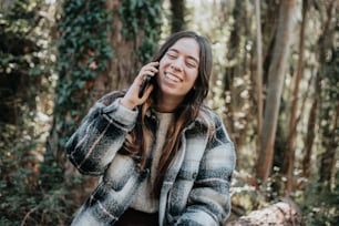 a woman talking on a cell phone in the woods