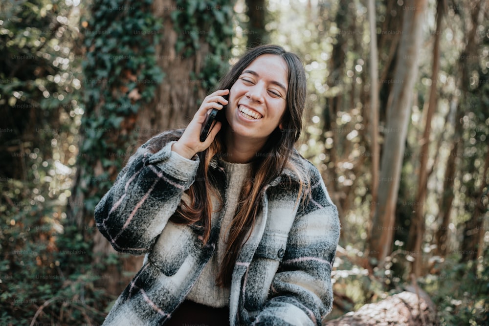 a woman talking on a cell phone in the woods