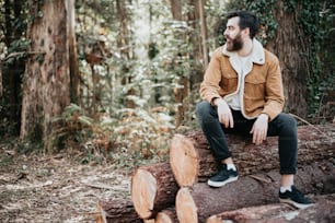 a man sitting on a log in the woods