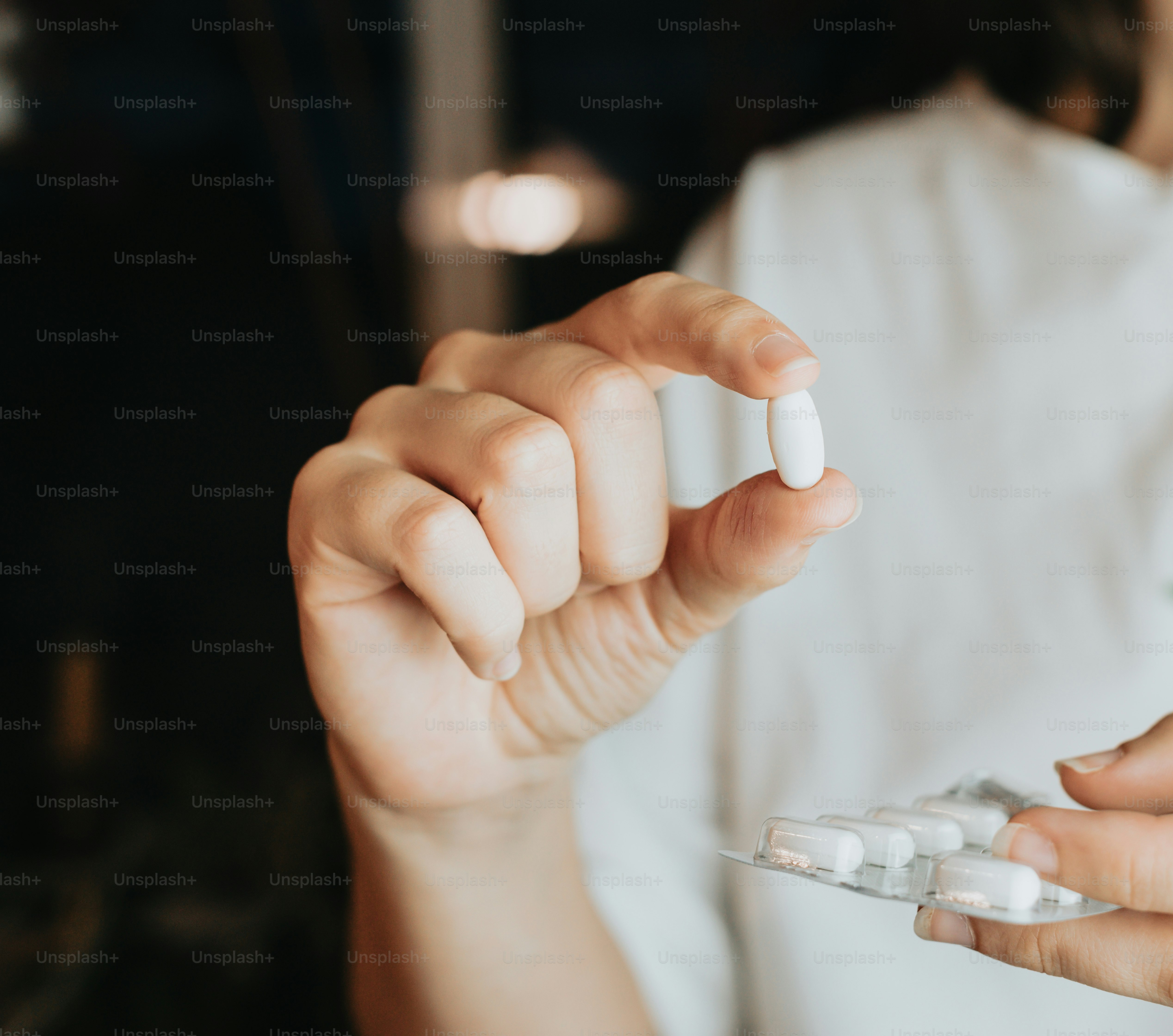 a close up of a person holding several pills