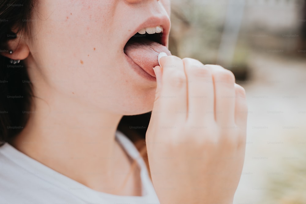 a close up of a person holding a piece of food in their mouth
