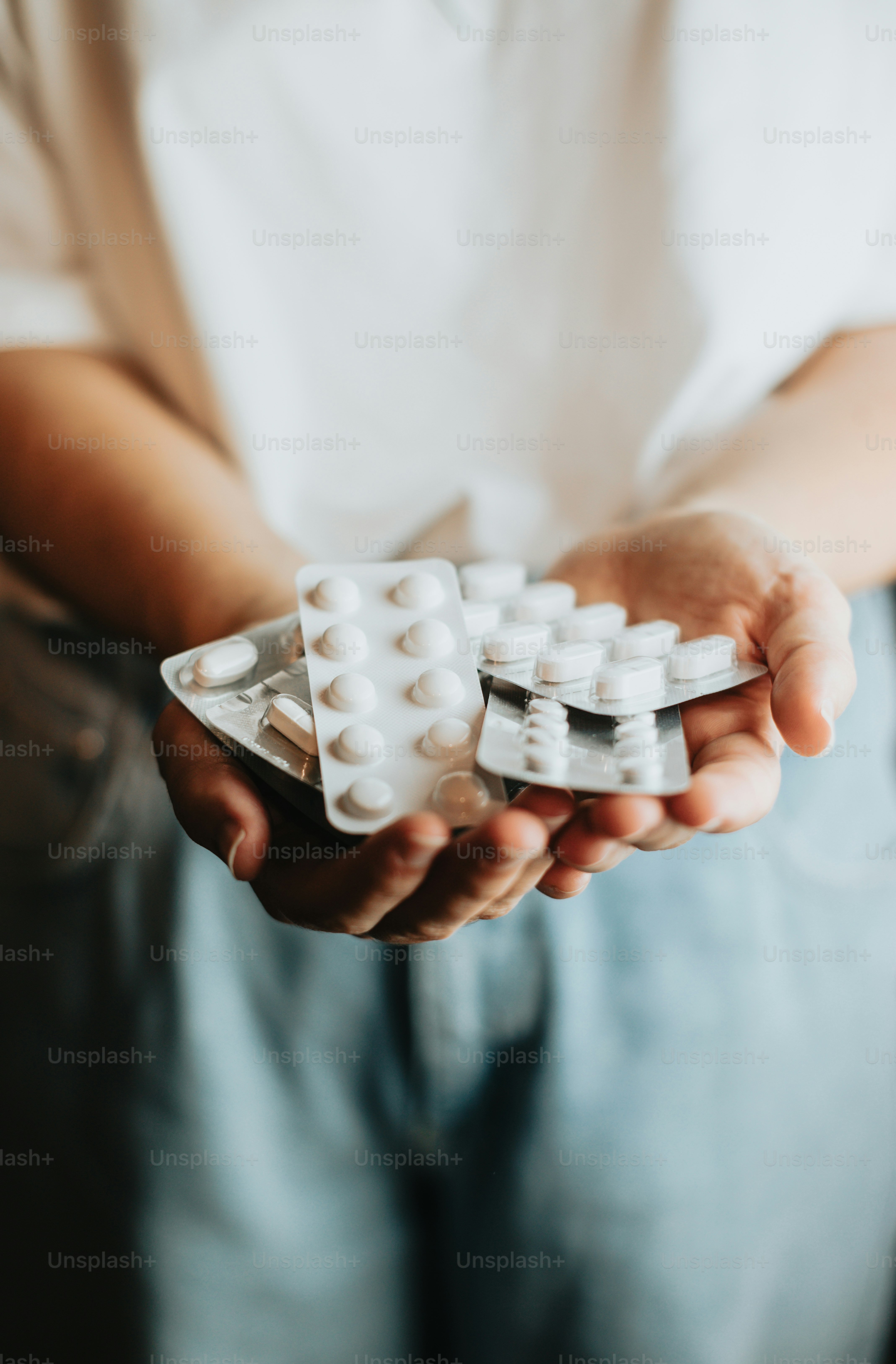 a person holding a pack of pills in their hands