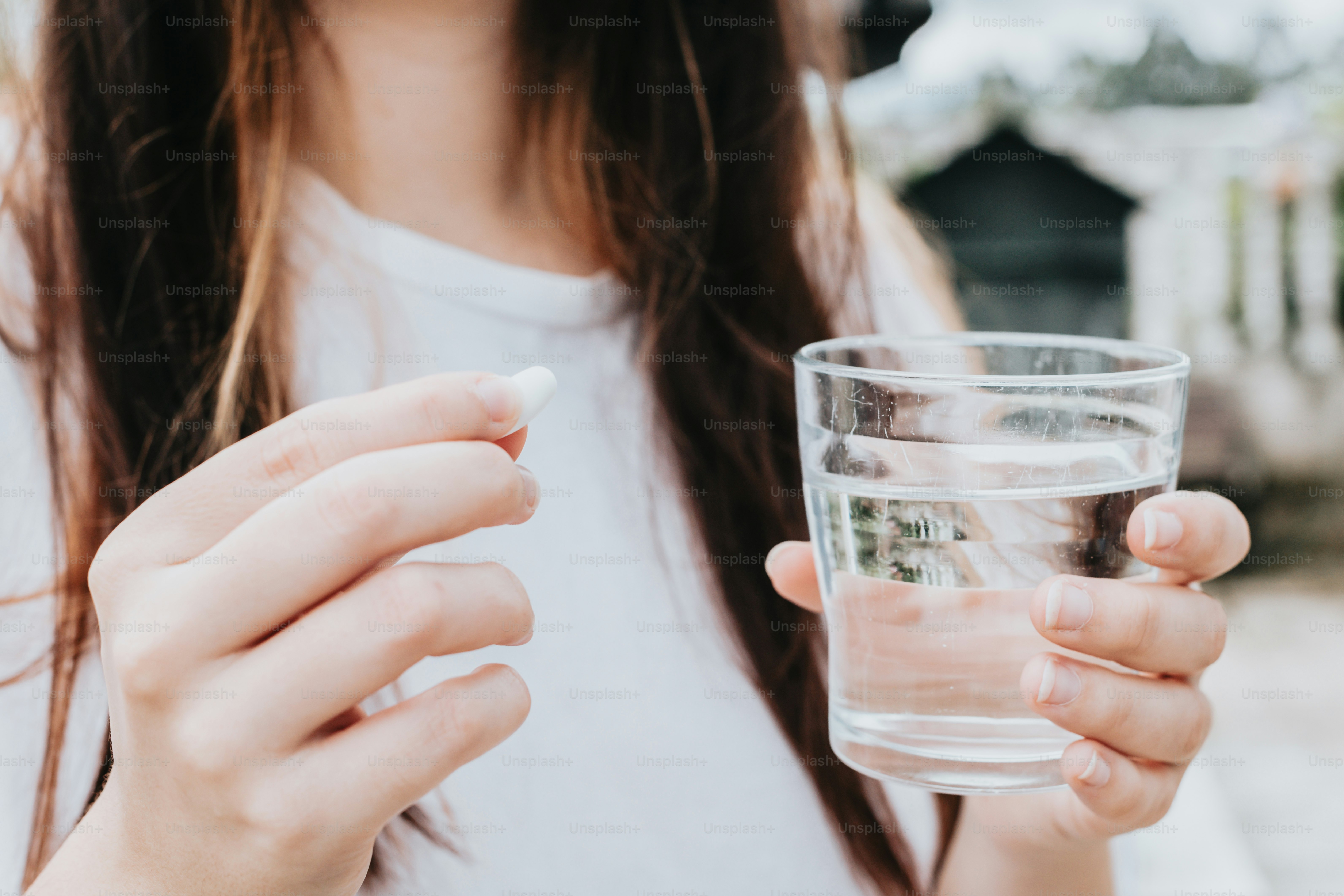a close up of a person holding a glass of water