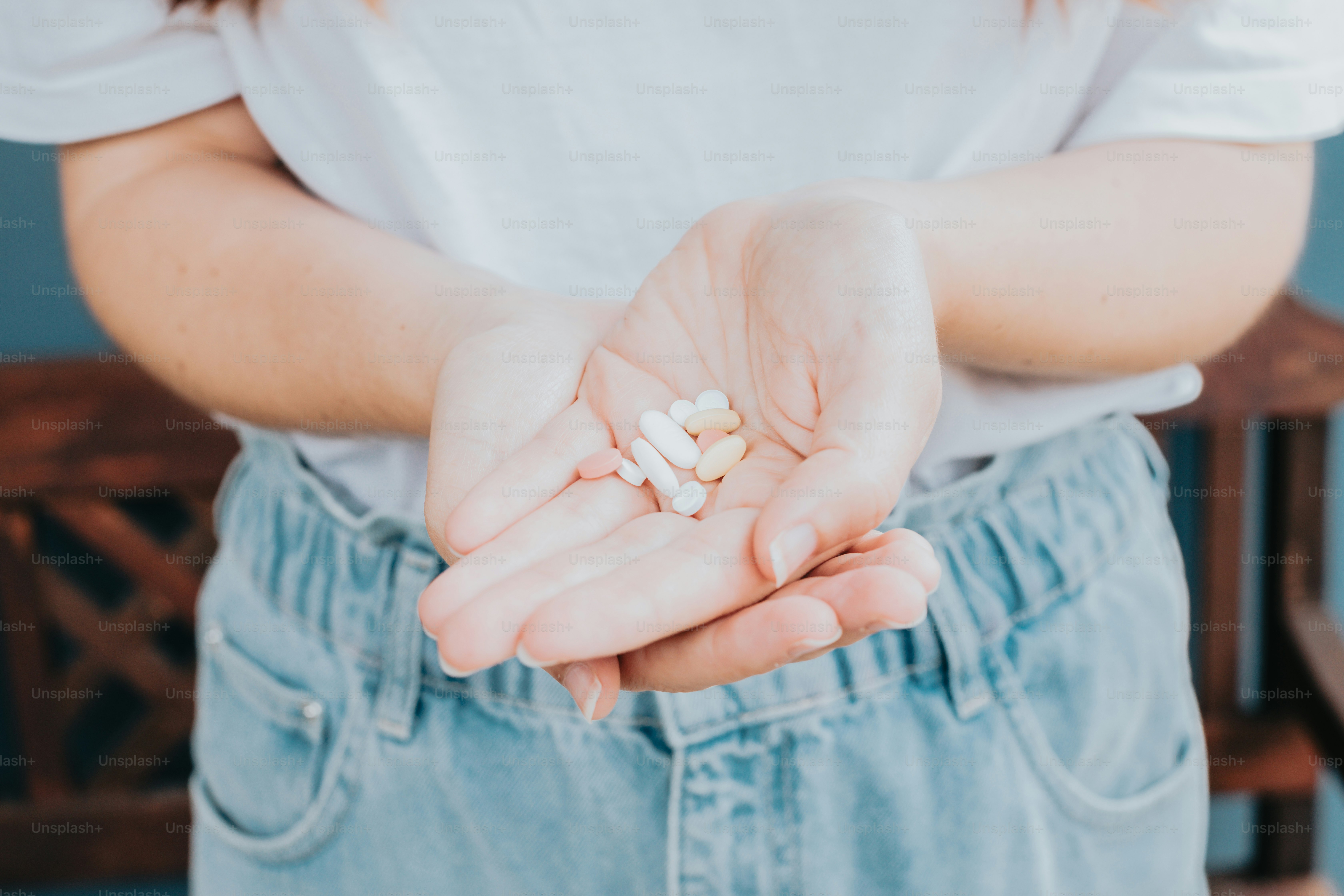 a woman holding a handful of pills in her hands
