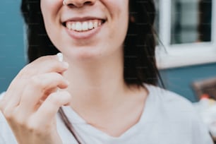 Une femme souriante et tenant une brosse à dents à la main
