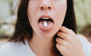 une femme tenant une pilule dans sa bouche