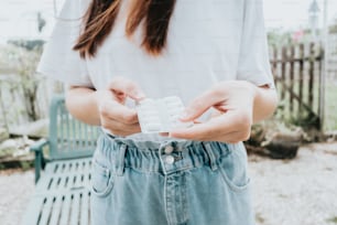 a woman holding a pill bottle in her hands