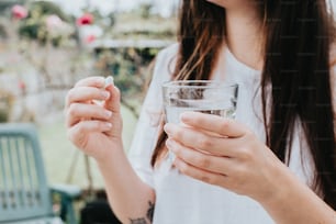 a woman holding a glass of water and a cigarette