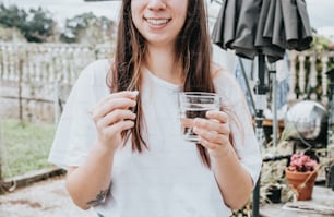 a woman holding a glass of water in her hands