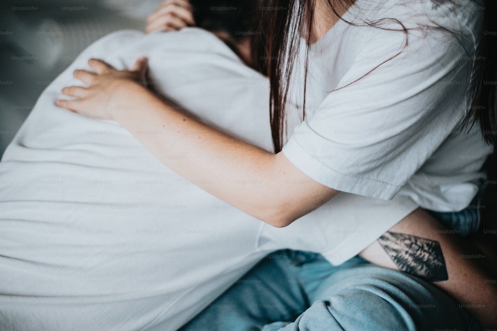 a woman with a tattoo on her arm hugging a man