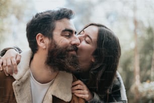 a man and a woman are kissing in the woods