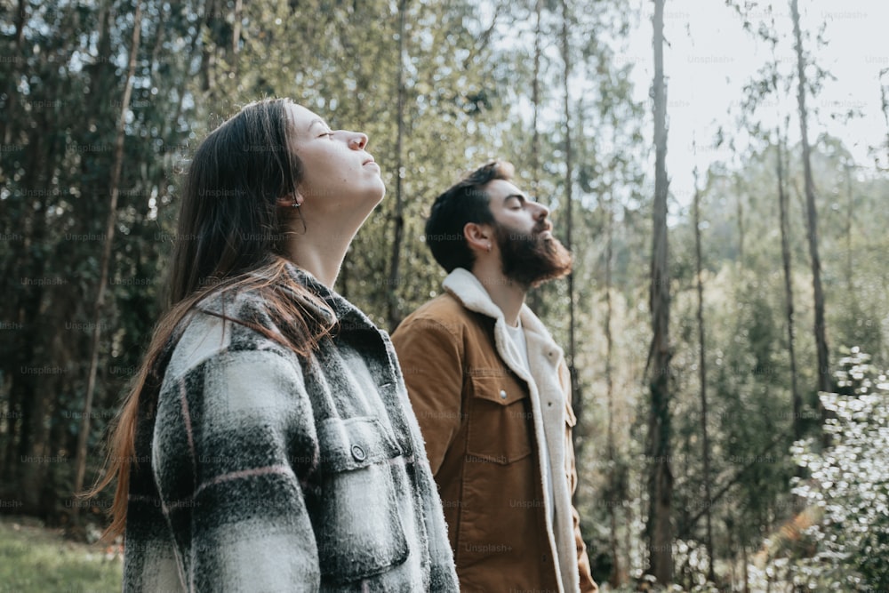 a man and a woman standing in the woods