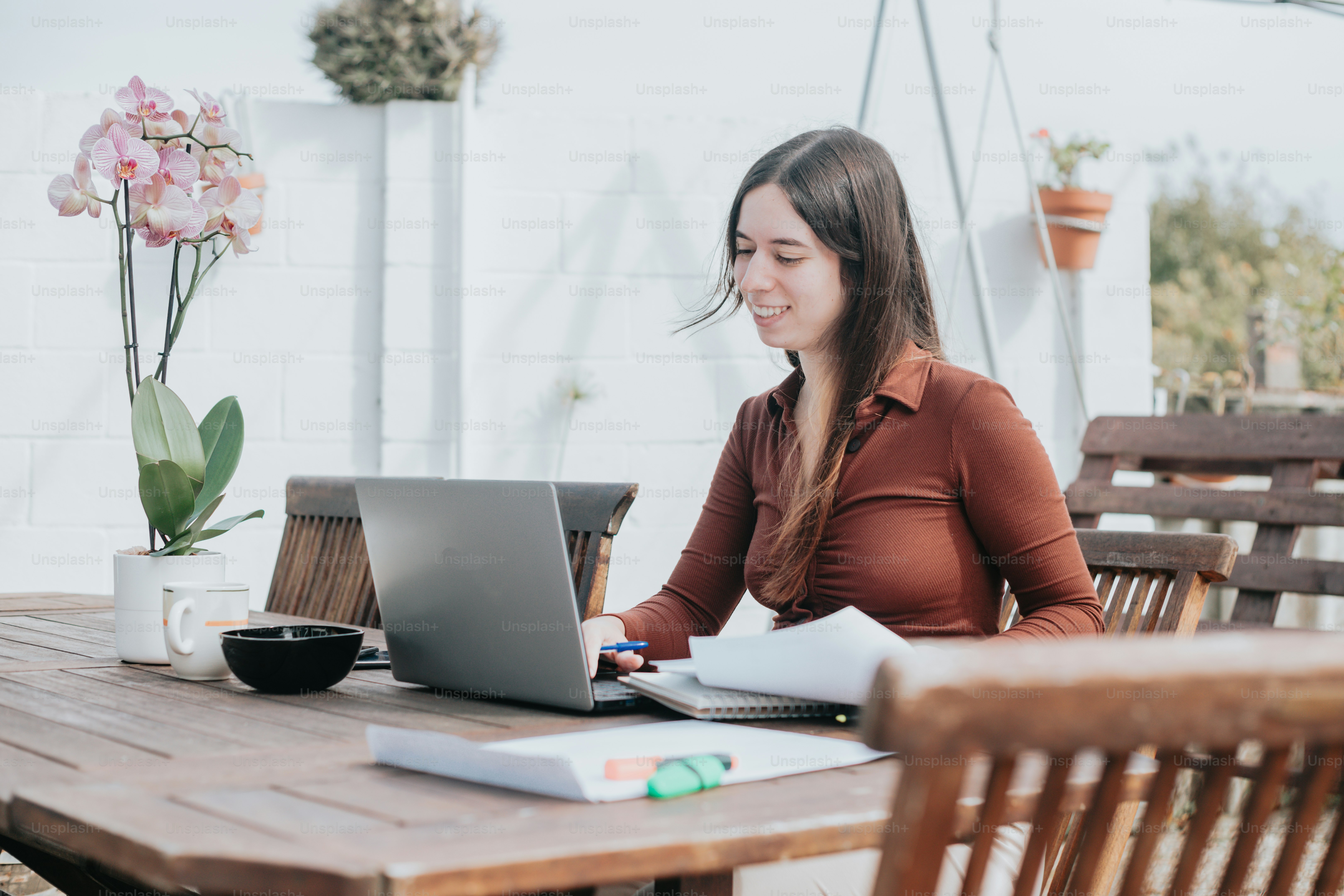 a woman sitting at a table using a laptop computer