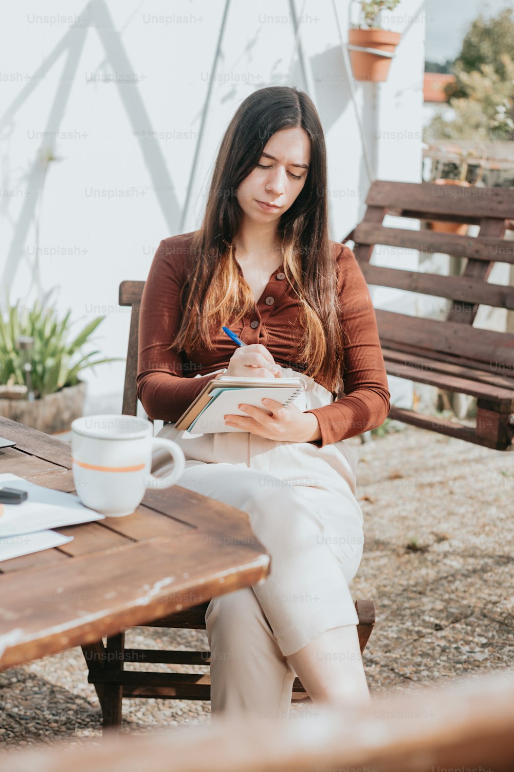 uma mulher sentada em uma mesa com um livro e uma xícara de café