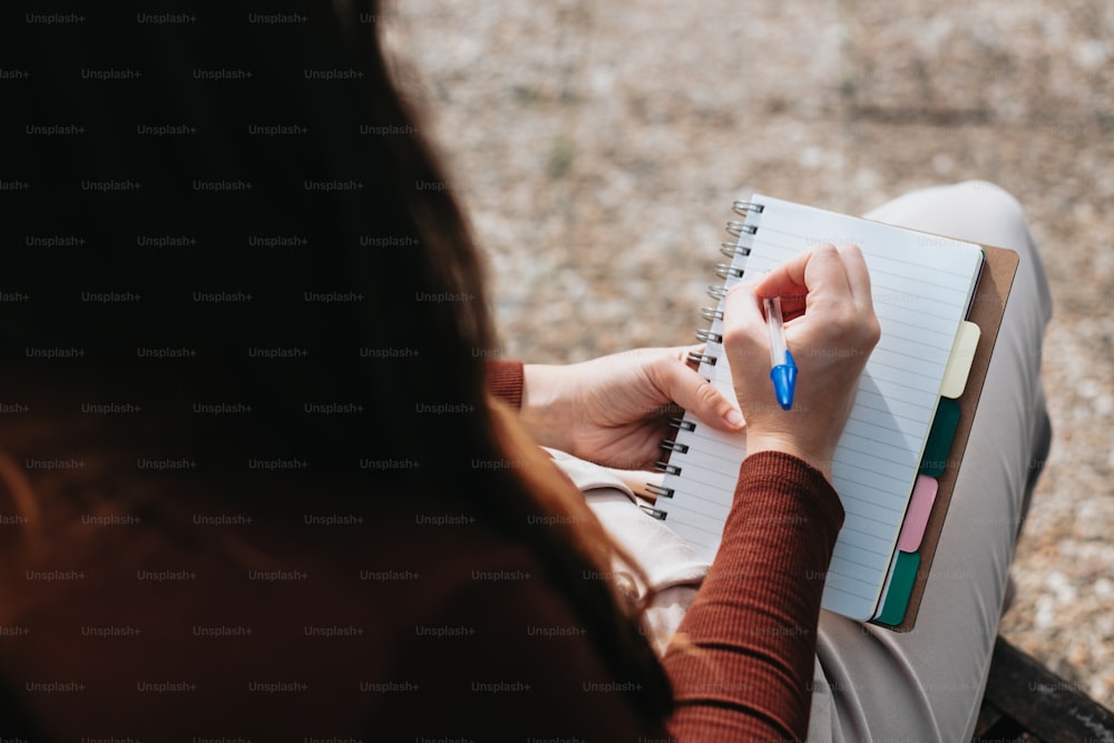 una donna seduta su una panchina che scrive su un quaderno