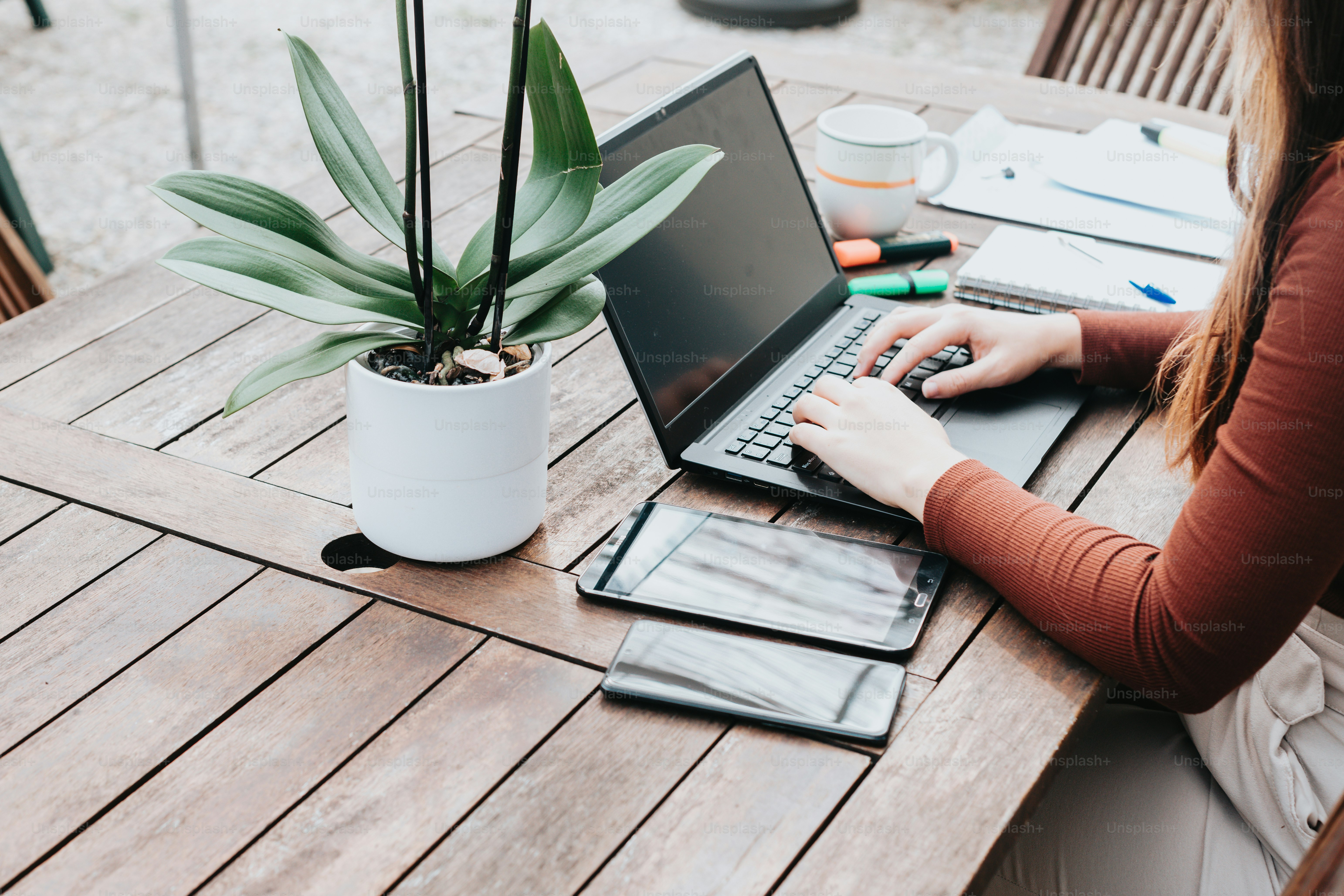 a woman sitting at a table using a laptop computer