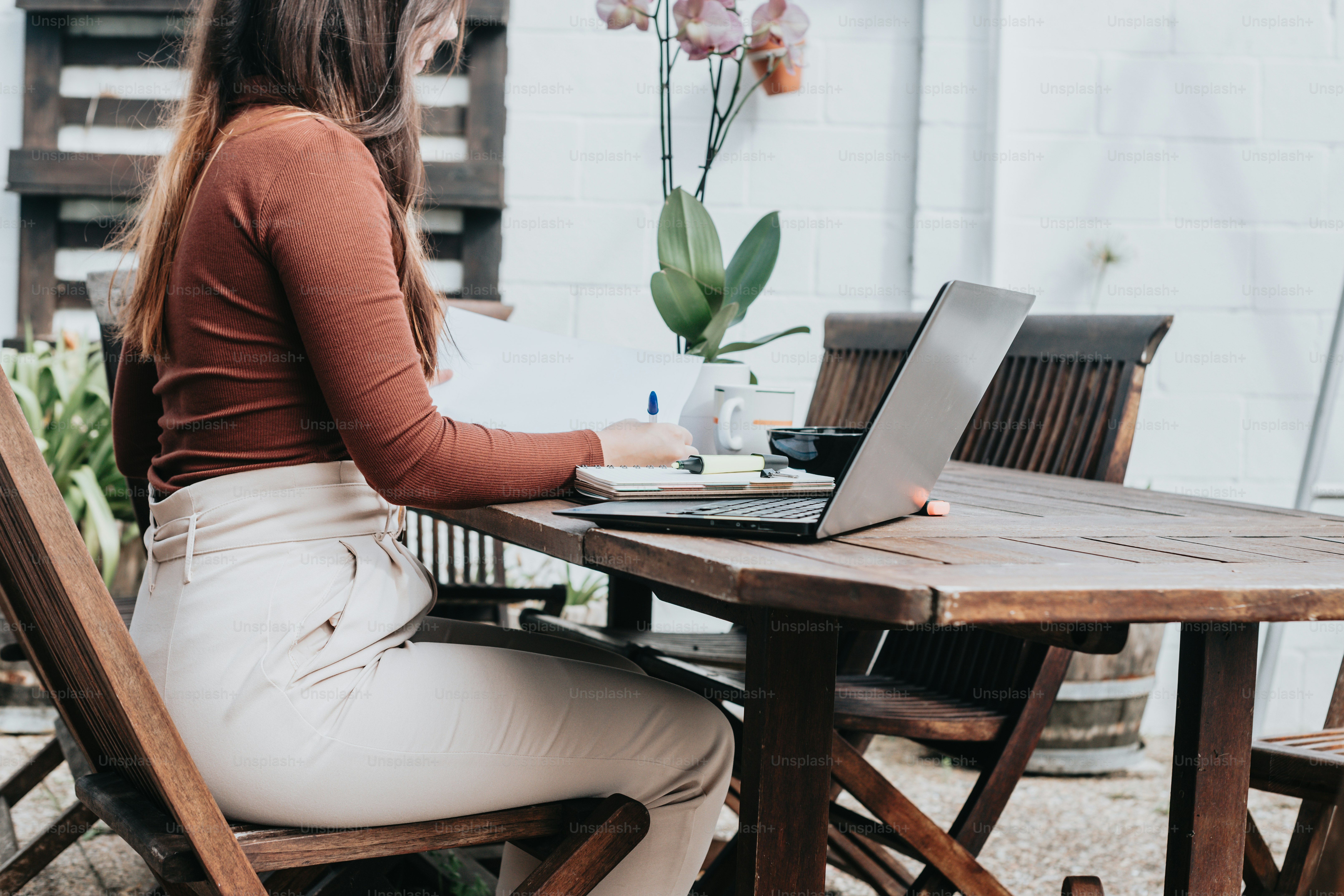 a woman sitting at a table using a laptop computer