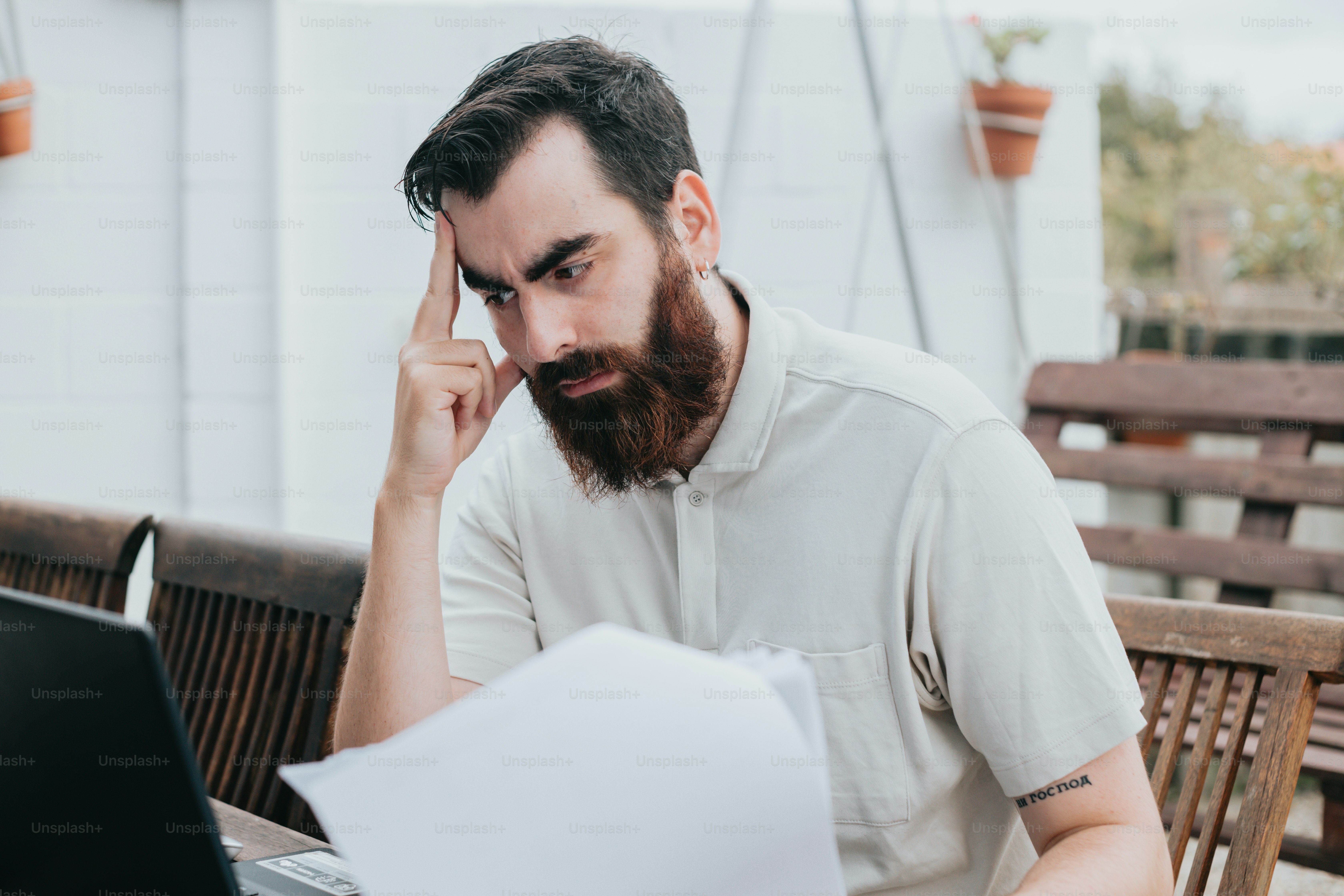 a man with a beard sitting in front of a laptop